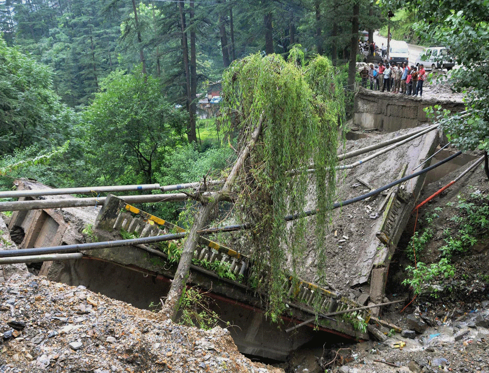 Onlookers looking at the collapsed bridge after heavy downpour in Shimla on Tuesday. PTI Photo