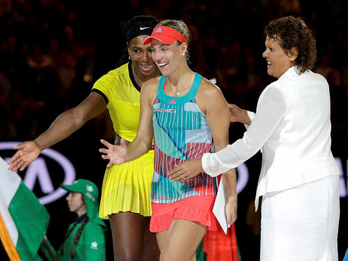 Angelique Kerber, center, of Germany is assisted Serena Williams, left, of the United States and former champion Evonne Goolagong Cawley to the podium after winning the women's singles final at the Australian Open tennis championships in Melbourne, A...