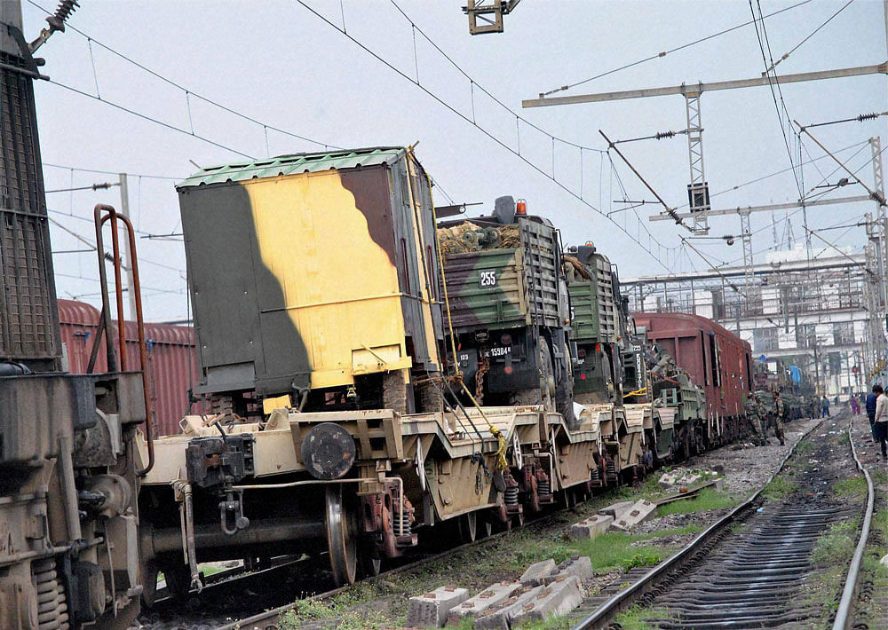 Army vwhicles and articles being carries on a goods train at Allahabad railway station on Monday. Two army jawans serious injured by the high tension electric wire when they tried to cover their goods which touched the wires. PTI Photo