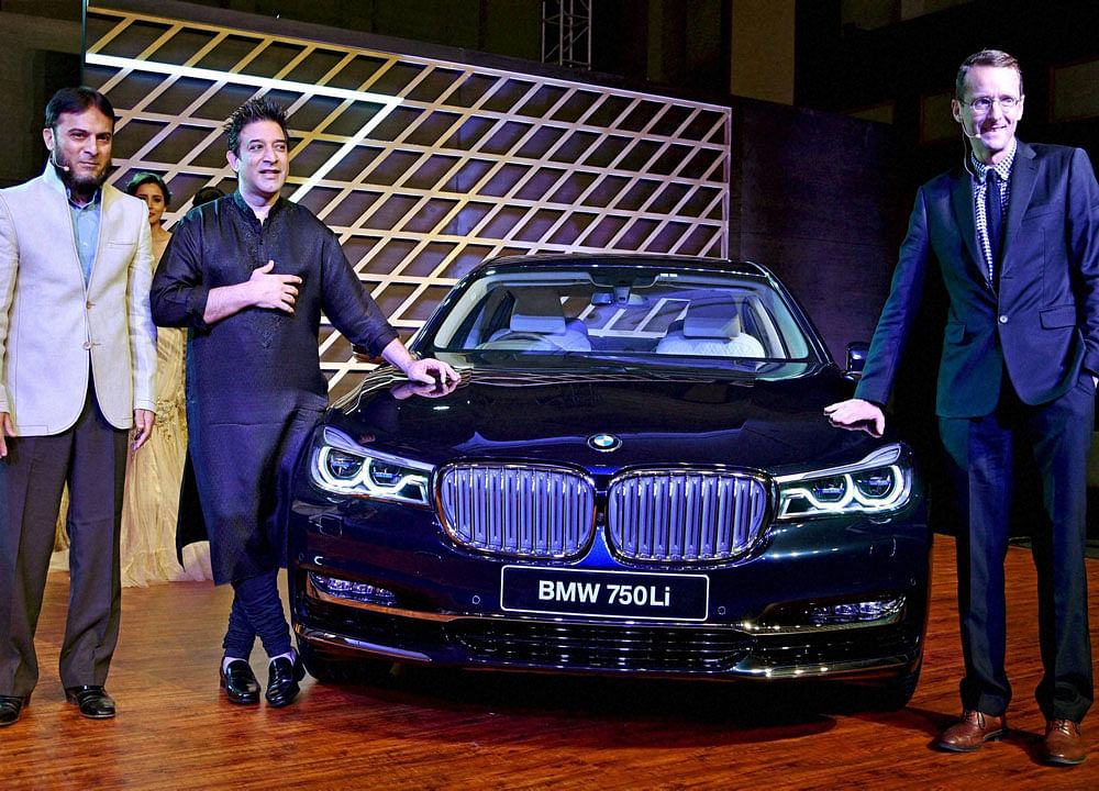 BMW India's Hans-Christian Bartels (CFO) (R) with fashion designer Sumeet Verma (M) and Talha Sareshwala (BMW Ahmedabad) (L) launches BMW 750 Li in Ahmedabad on Sunday. PTI Photo