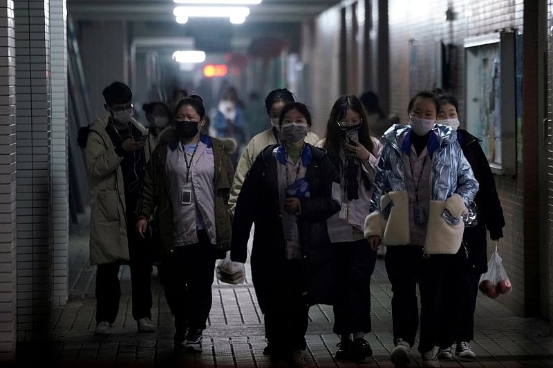 Workers wearing masks walk outside their dormitory, in an electronics manufacturing factory in Shanghai, China, as the country is hit by an outbreak of a new coronavirus. (Reuters Photo)