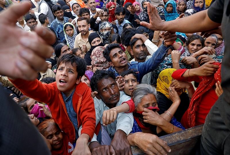 People crowd to receive free grocery items being distributed outside a relief camp after they fled their homes following Hindu-Muslim clashes triggered by a new citizenship law, in Mustafabad in the riot-affected northeast of New Delhi, India. (Reuters Photo)