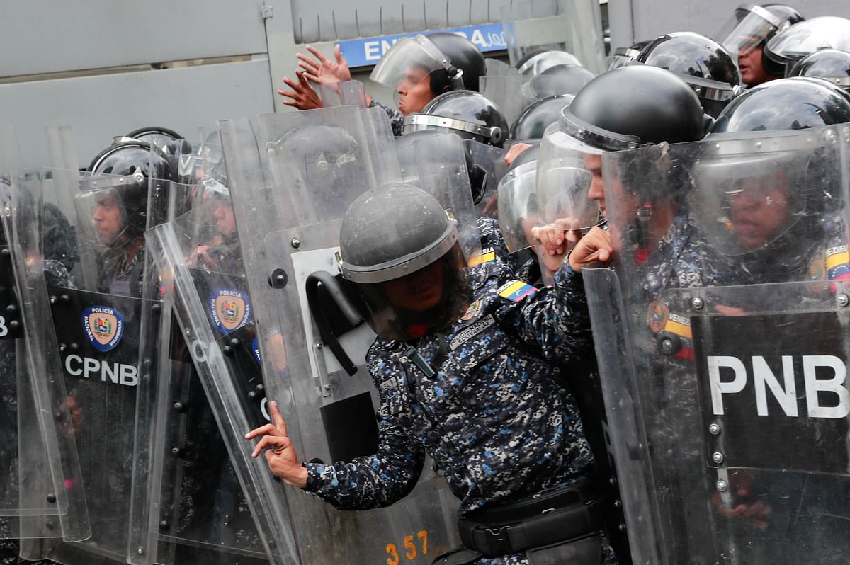 Security forces stand guard during a protest in Caracas, Venezuela. (Credit: Reuters)