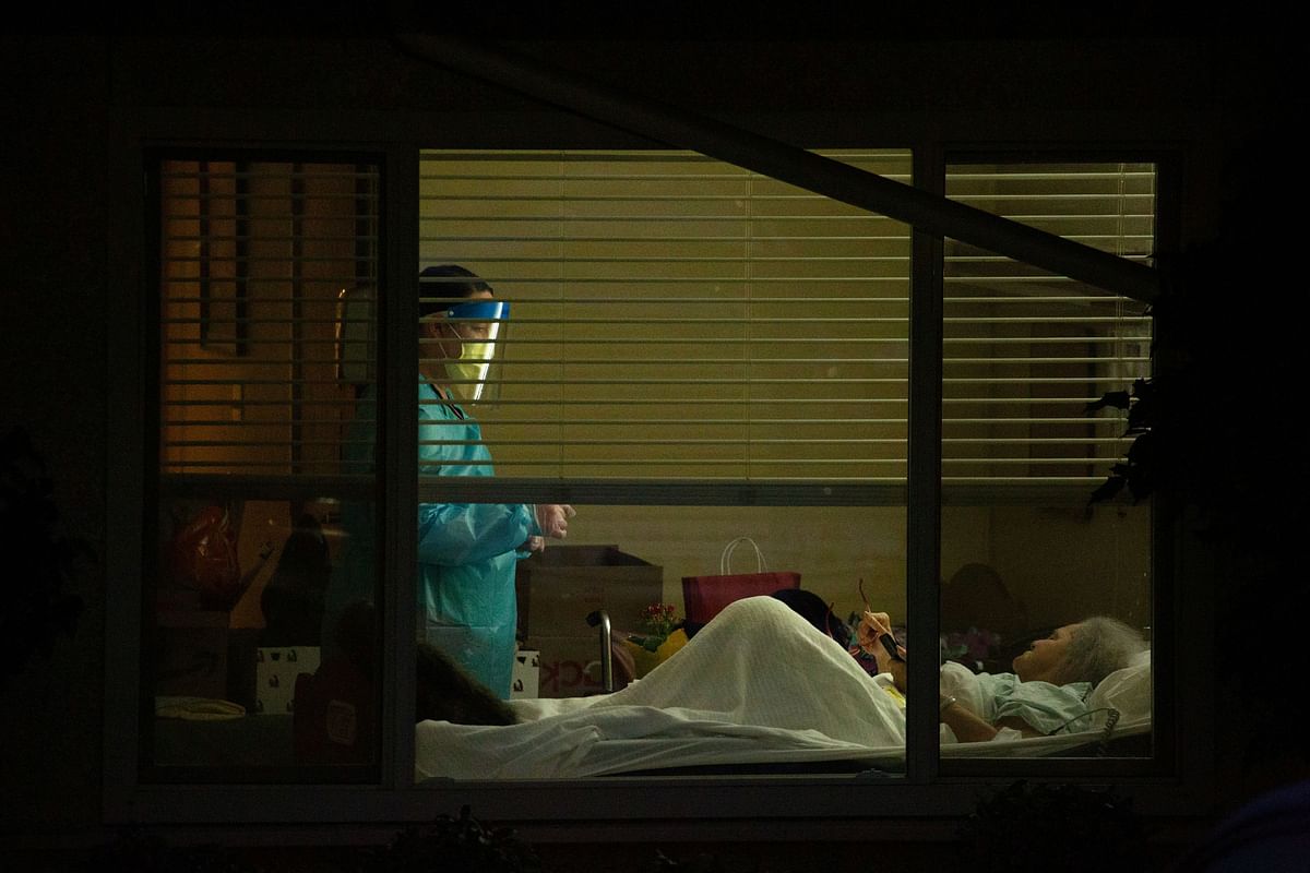 A healthcare worker attends to Susan Hailey, who has tested positive for coronavirus, at the Life Care Center of Kirkland. (Credit: Reuters)