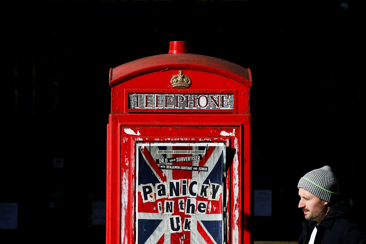 A pedestrian walks past an advertisement for 'Panicky in the UK' displayed on a phone box in the Soho district after they closed because of the spread of coronavirus disease (COVID-19), in London. (Credit: Reuters)