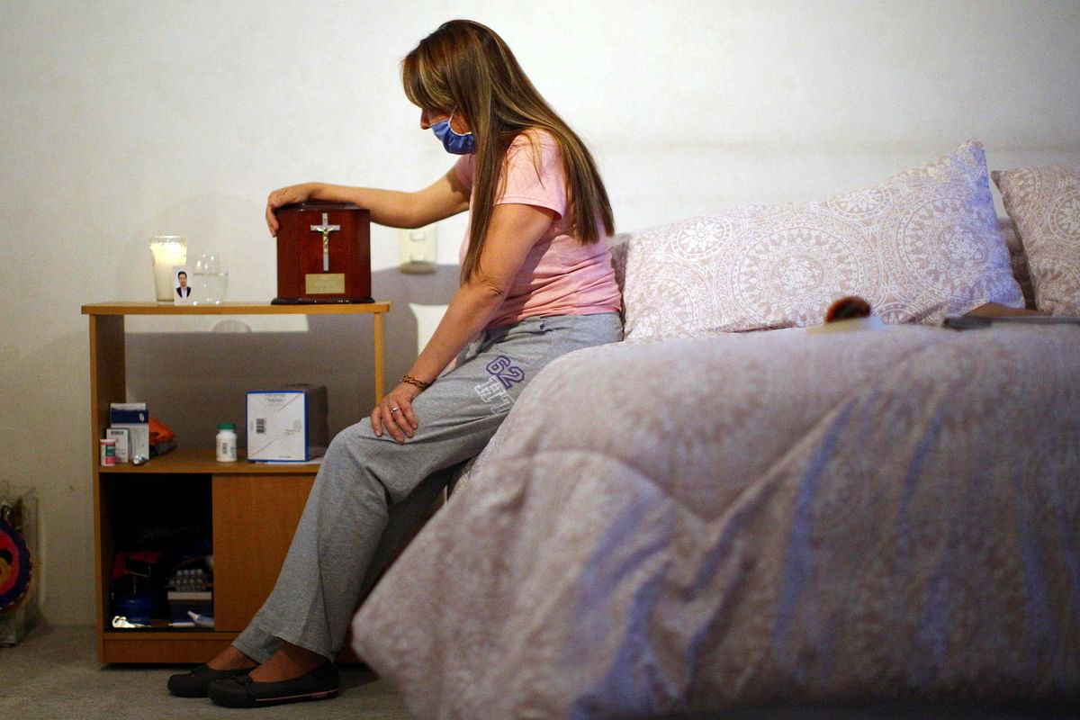 Monica Samudio, 46, whose husband Jorge Garcia, 51, died from the coronavirus disease (COVID-19), holds a box containing Garcia?s ashes, while sitting in her new apartment, in Mexico City. (Credit: Reuters)