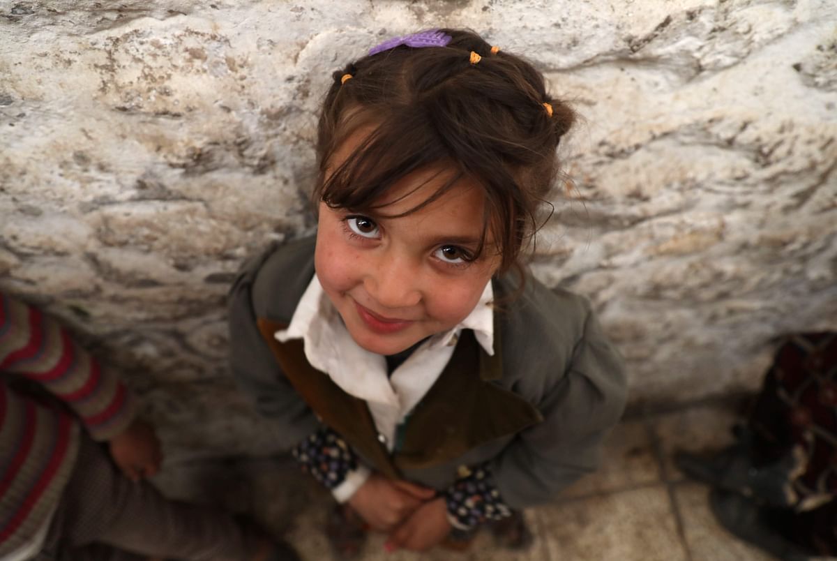 A displaced Syrian girl is pictured in a former jail turned into a makeshift shelter in the northwestern city of Idlib. (Credit: AFP)