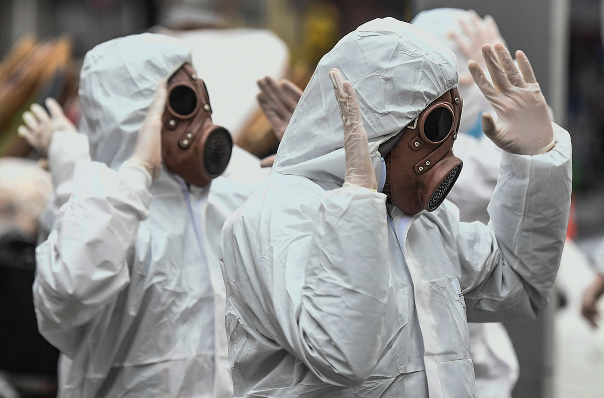Youngsters wearing protective suites take part in a performance as part of an awareness campaign against the spread of the new coronavirus, COVID-19, in Bogota. (Credit: AFP)