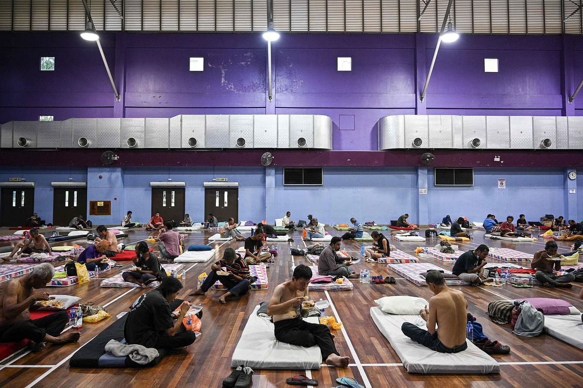 Homeless people practice social distancing as they eat their lunch at a temporary shelter during the Movement Control Order in Malaysia. (Credit: AFP Photo)