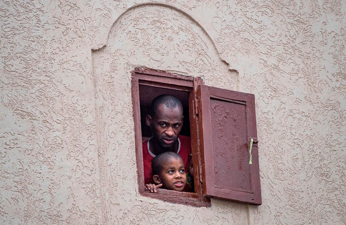 Moroccans confined at home watch from their window as health ministry workers disinfect a road in the capital Rabat on april 9, 2020 during the coronavirus COVID-19 pandemic crisis. (AFP Photo)