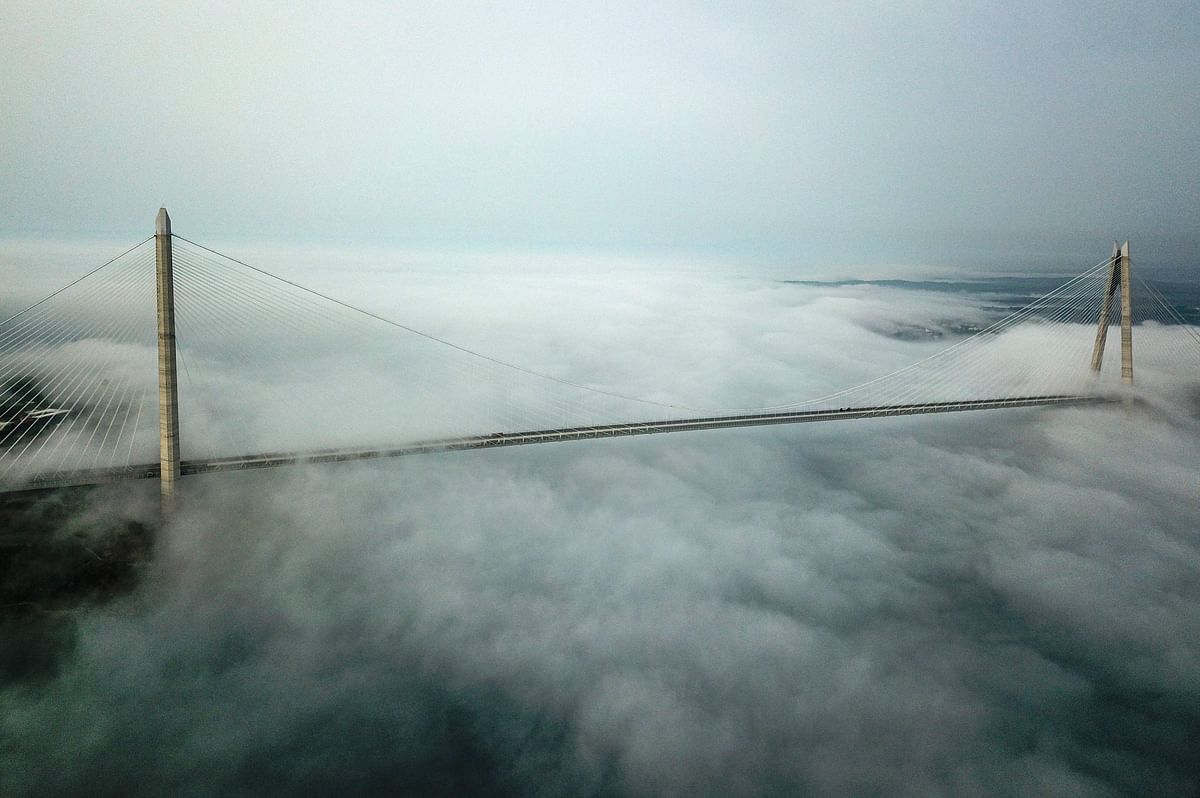 An aerial view shows the near-empty Yavuz Sultan Selim bridge as heavy fog settles in northern Istanbul, on May 17, 2020, during a four-day curfew aimed at curbing the spread of the COVID-19 pandemic, caused by the novel coronavirus. (Photo by AFP)