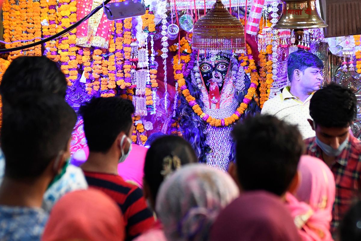 Hindu devotees pay their respect to a statue of the Goddess Kali at the Ancient Bhadrakali Temple in Amritsar on May 18, 2020. (Photo by AFP)