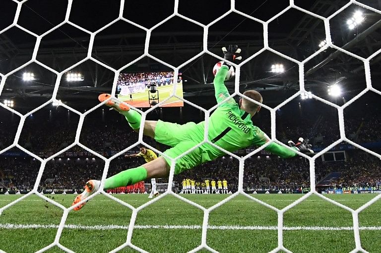 England's goalkeeper Jordan Pickford (C) jumps to catch the ball as Colombia's forward Carlos Bacca misses his penalty kick (rear C) during the penalty shoot-out of the Russia 2018 World Cup round of 16 football match between Colombia and England at the Spartak Stadium in Moscow on July 3, 2018.  FRANCK FIFE / AFP