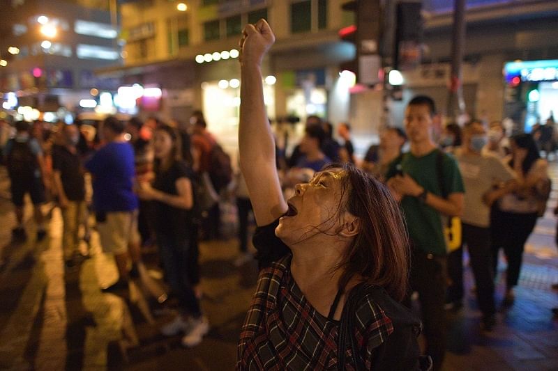 A woman shouts slogans toward the police outside the Mongkok district police station as people gather to pray at a makeshift shrine in Hong Kong. (AFP)