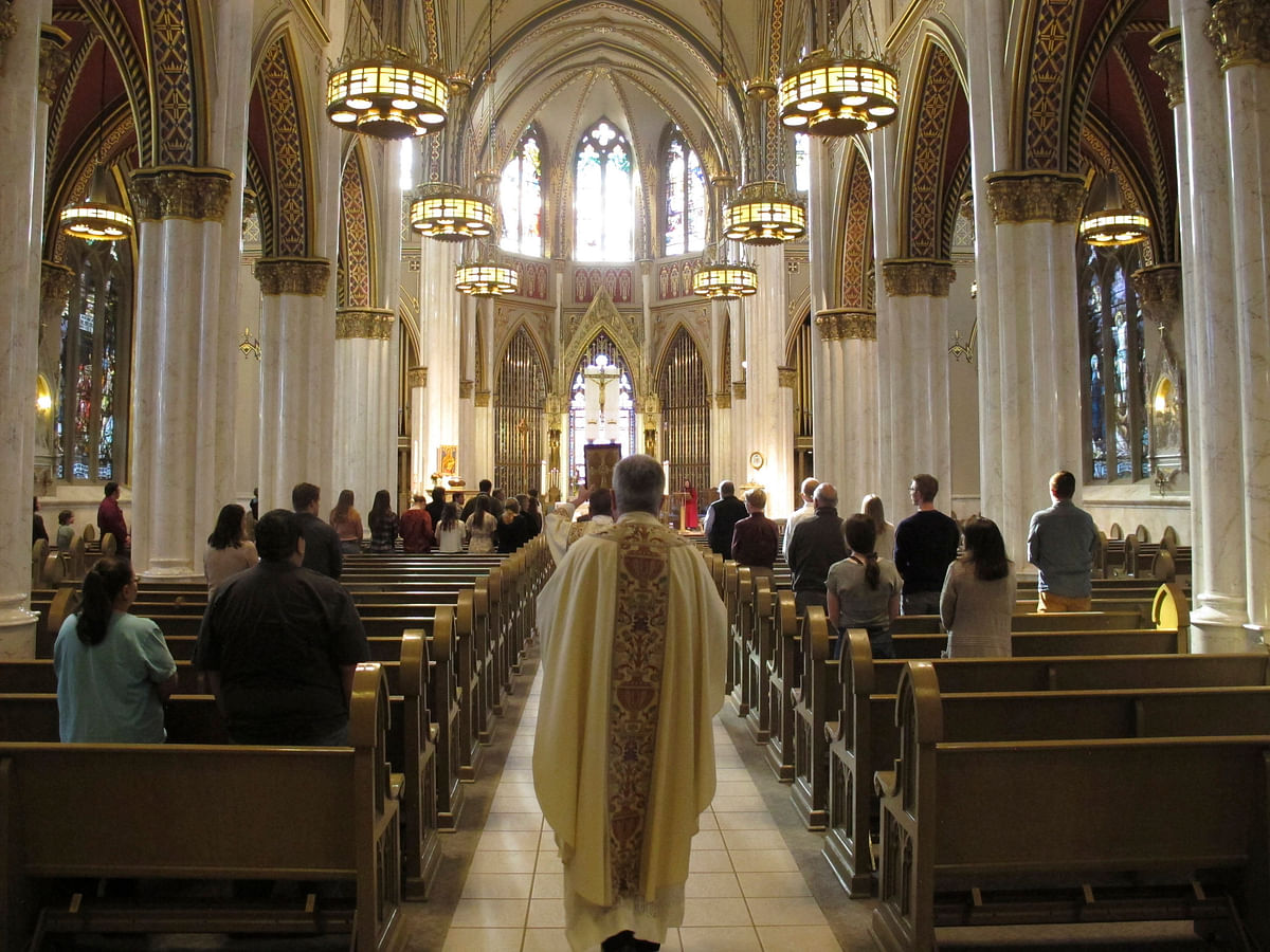 Helena: Rev. Msgr. Kevin O'Neill walks down the aisle of the Cathedral of St. Helena to begin mass in Helena, Mont.. (AP Photo)