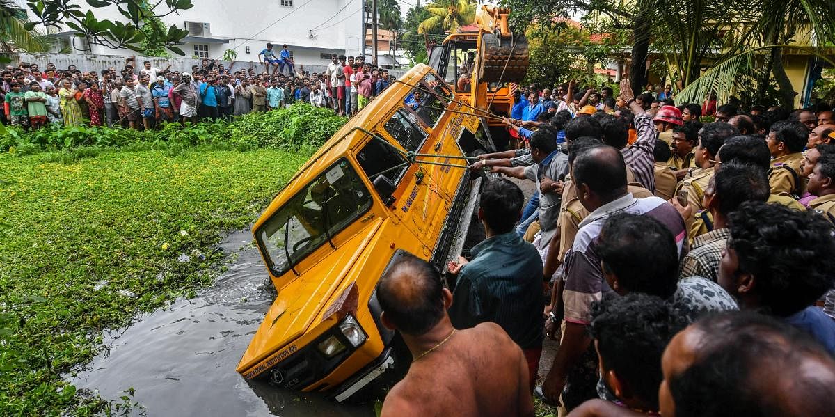 A play school van being pulled out of a temple pond after an accident at Maradu in Ernakulam district on Monday. PTI Photo
