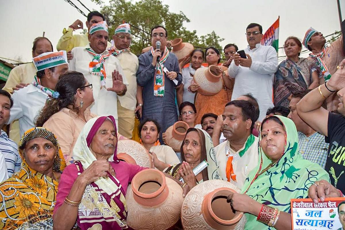 DPCC President Ajay Maken with other Congress workers stage a protest against the AAP government over the acute water shortage and failure to provide clean drinking water, in New Delhi on Tuesday. PTI Photo