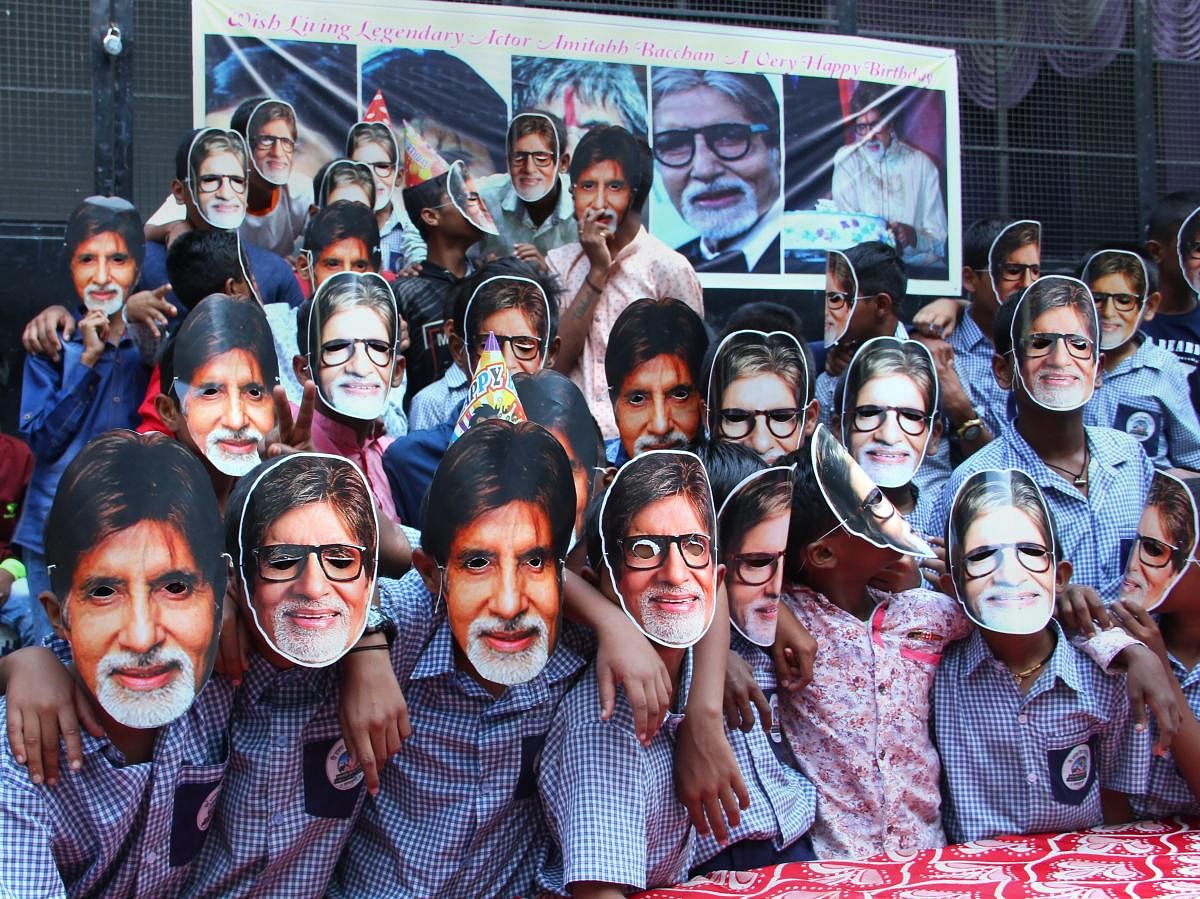 Fans wear masks of Bollywood actor Amitabh Bachchan as they celebrate his 76th birthday, in Pune on Thursday. (PTI photo)