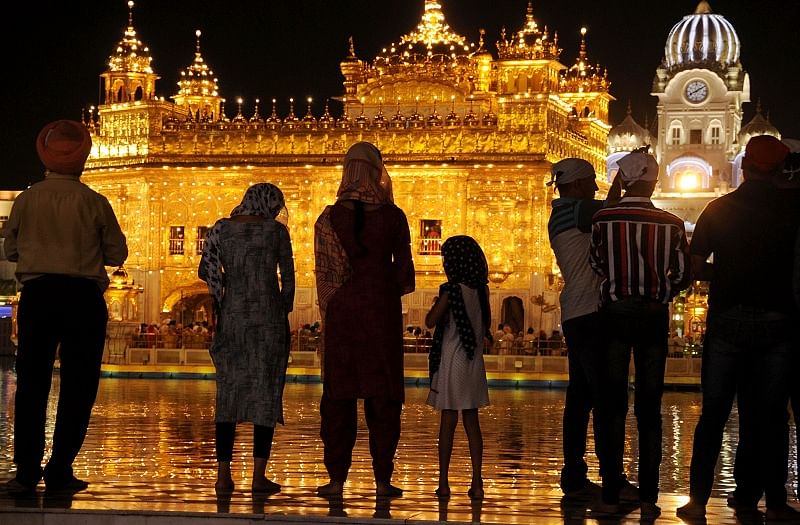 Devotees offer prayers at the illuminated Harmandir Sahib (Golden Temple) on the occasion of birth anniversary of Sikh Guru Har Krishan Sahib, in Amritsar. (PTI Photo)