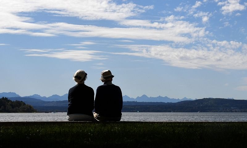 An elder couple enjoys the late warm summer weather and the Alp mountains view at lake Ammersee in Herrsching, southern Germany. (AFP)