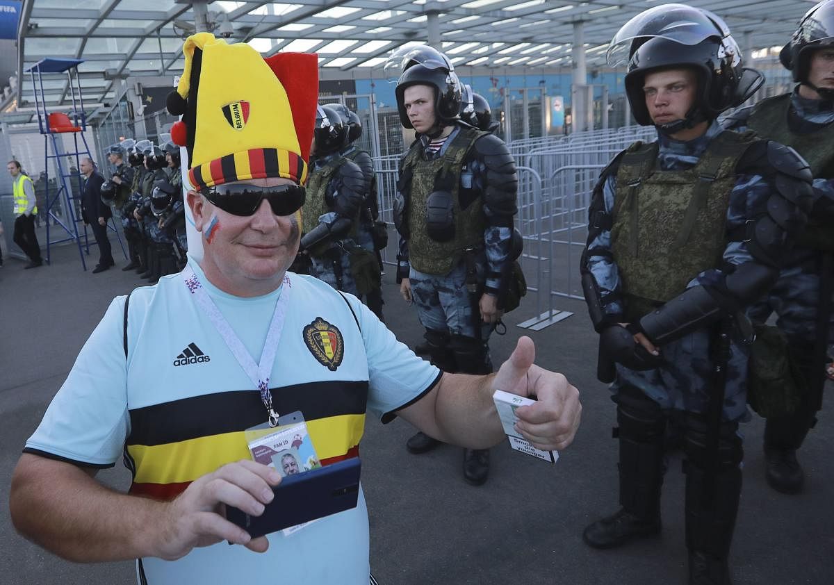 A supporter of Belgium poses for a picture as riot policemen stand guard after the match. Reuters  Photo