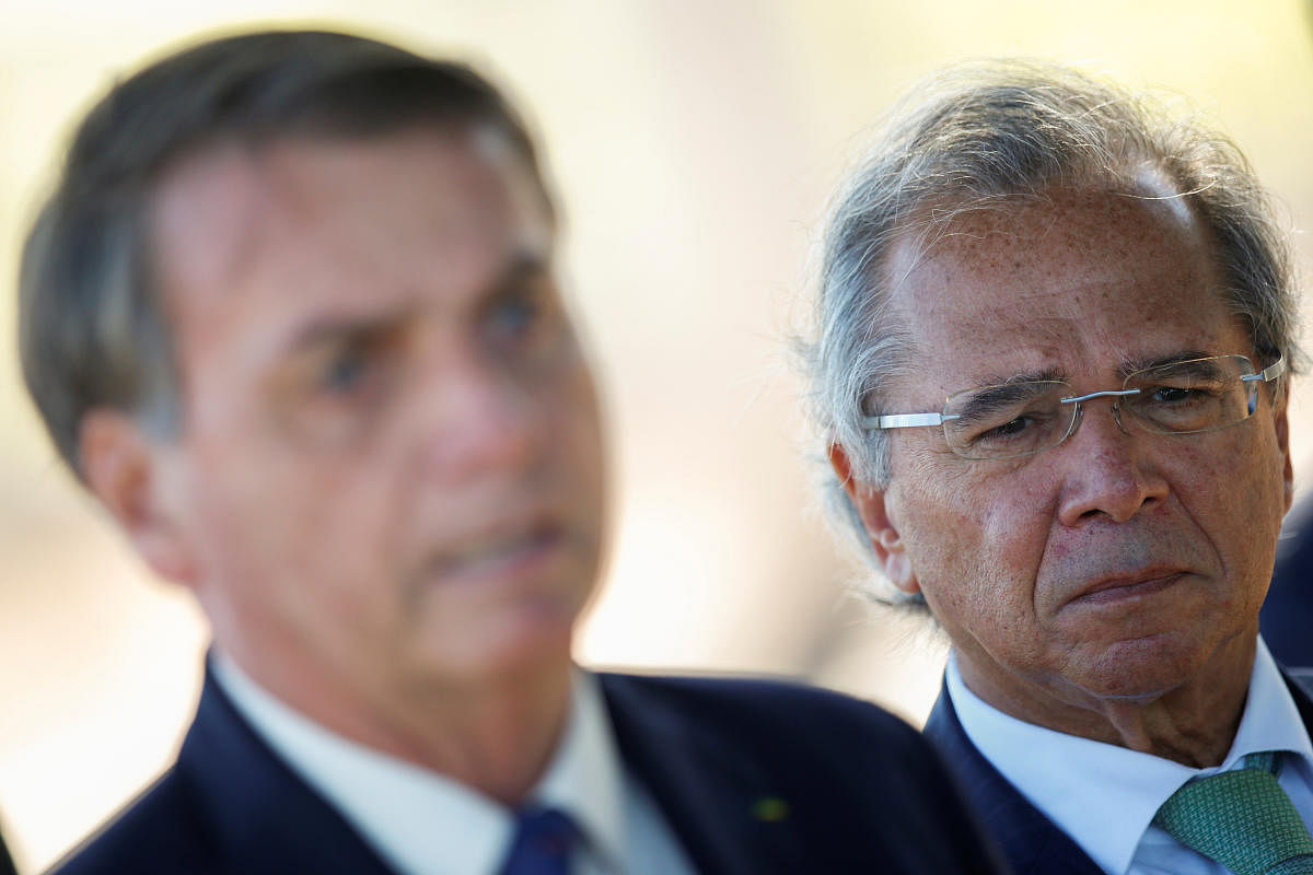razil's Economy Minister Paulo Guedes listens to Brazil's President Jair Bolsonaro, while leaving Alvorada Palace in Brasilia, Brazil. (Reuters photo)