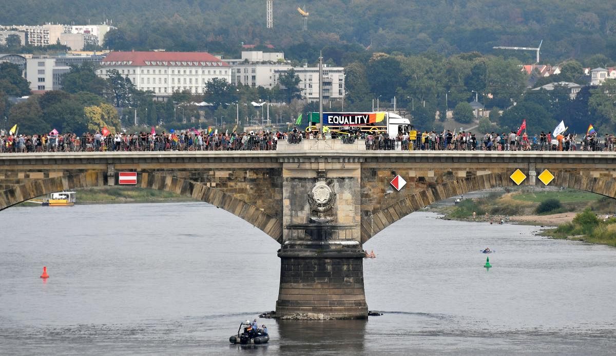 People walk on a bridge over the river Elbe as they take part in a demonstration titled
