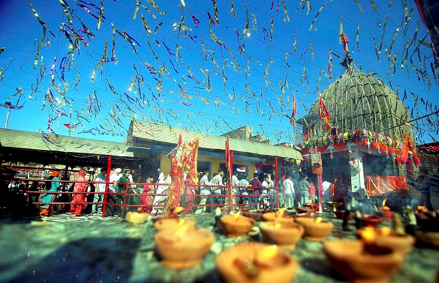 Devotees stand in queues to offer prayer at historical Goddess Kali temple on the second day of Navratri, in Jammu. (PTI)