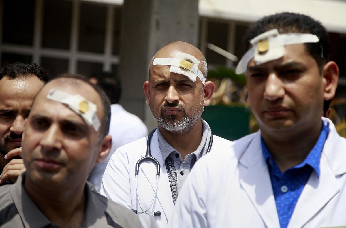 Doctors of SMGS hospital wearing bandages on their heads protest to show solidarity with their counterparts in West Bengal, who stopped work on Tuesday protesting against the assault on their colleagues, in Jammu, Saturday, June 15, 2019. PTI