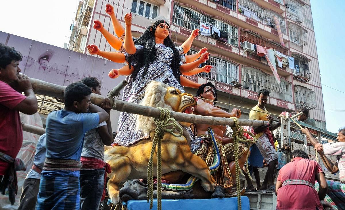 People carry Lord Durga idol to a pandal for installation ahead of Durga Puja festival, in Kolkata on Friday. PTI photo