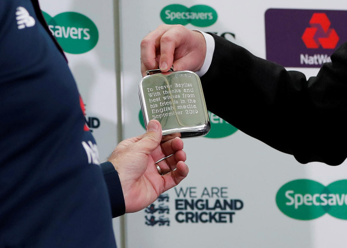 England head coach Trevor Bayliss is presented a hip flask by George Dobell during the press conference. (Photo by Reuters)