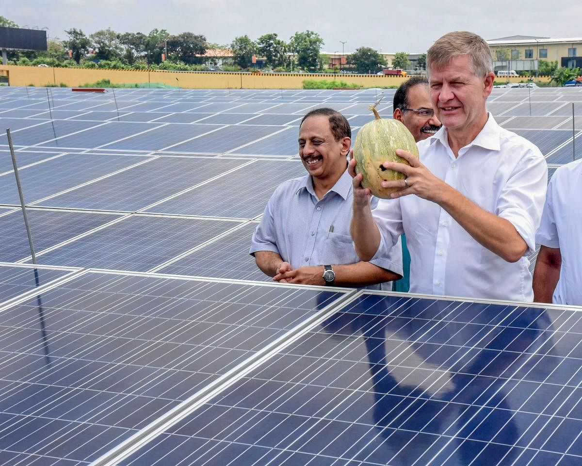 United Nations Environment Programme (UNEP) global chief Erik Solheim shows the Pumpkin which was cultivated in between the Solar panels during his visit at the world's first fully solar energy-powered airport Cochin International Airport (CIAL), in Kochi on Saturday. CIAL Airport Limited MD V.J Kurian is also seen. PTI Photo