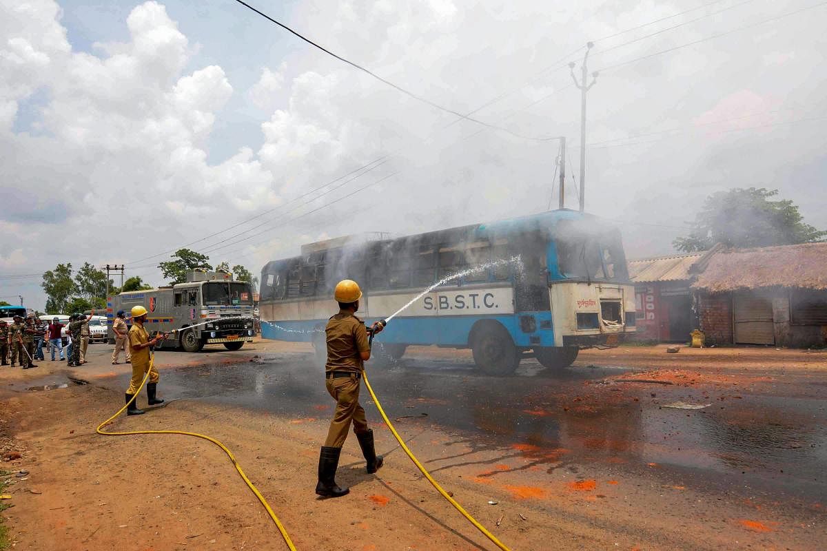 Firemen douse flames at a bus that was torched by the irate mob on NH-60 after a bus run over a woman and her daughter at Suri in Birbhum district of West Bengal on Saturday. PTI Photo