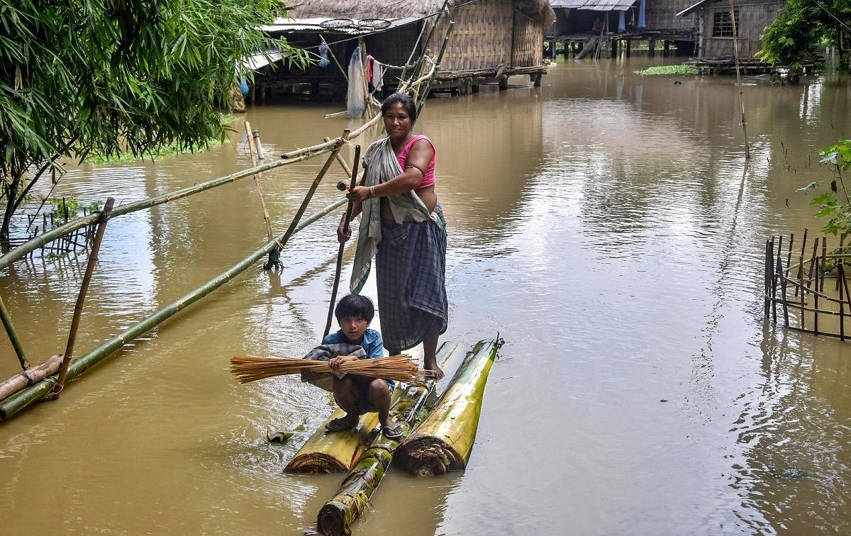 Villagers use a banana raft to cross flood affected area after monsoon rainfall, in Golaghat. PTI photo