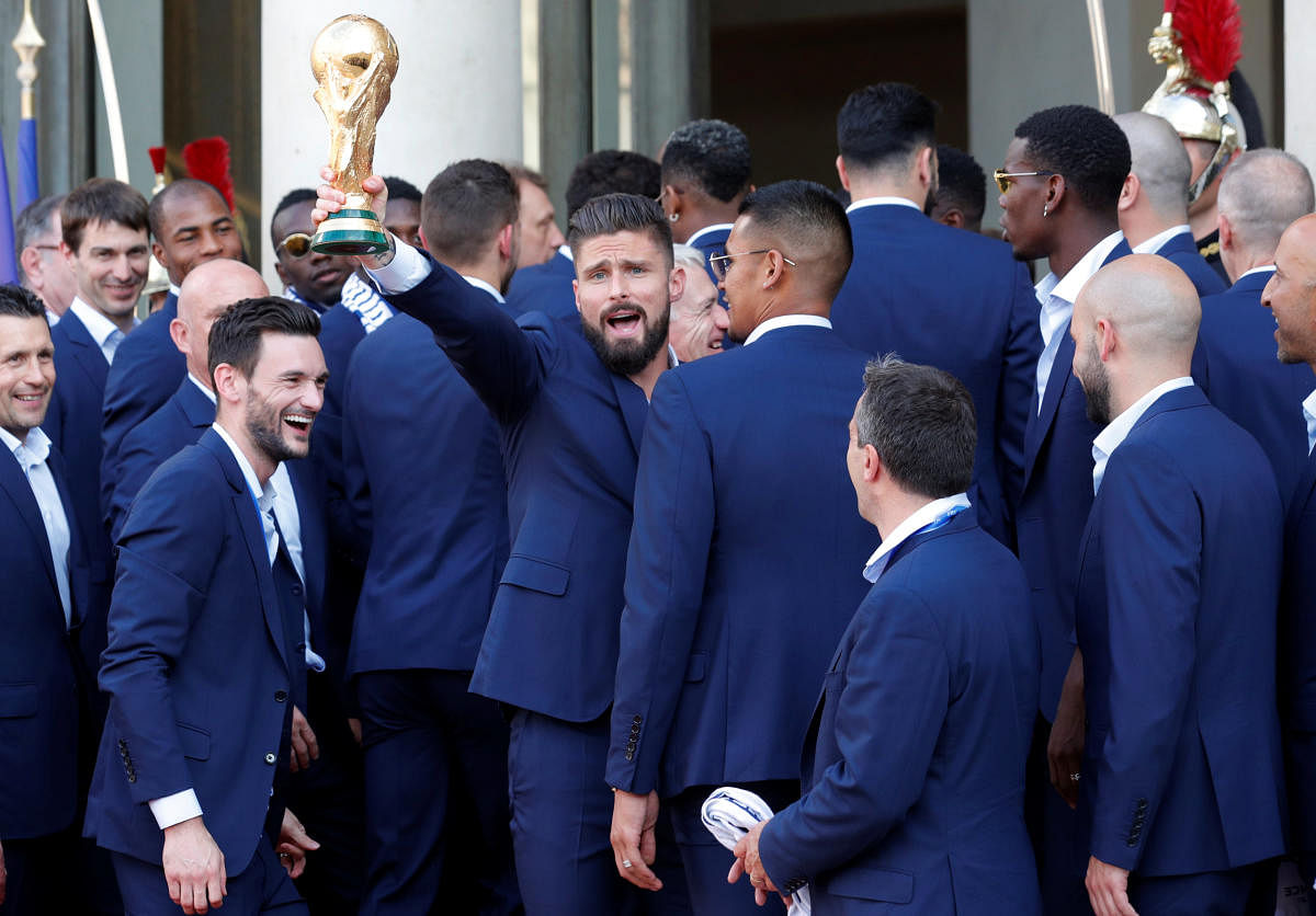 France player Olivier Giroud holds the trophy with team mates before a reception to honour the France soccer team after their victory in the 2018 Russia Soccer World Cup, at the Elysee Palace in Paris, France, July 16, 2018. (REUTERS/Philippe Wojazer)