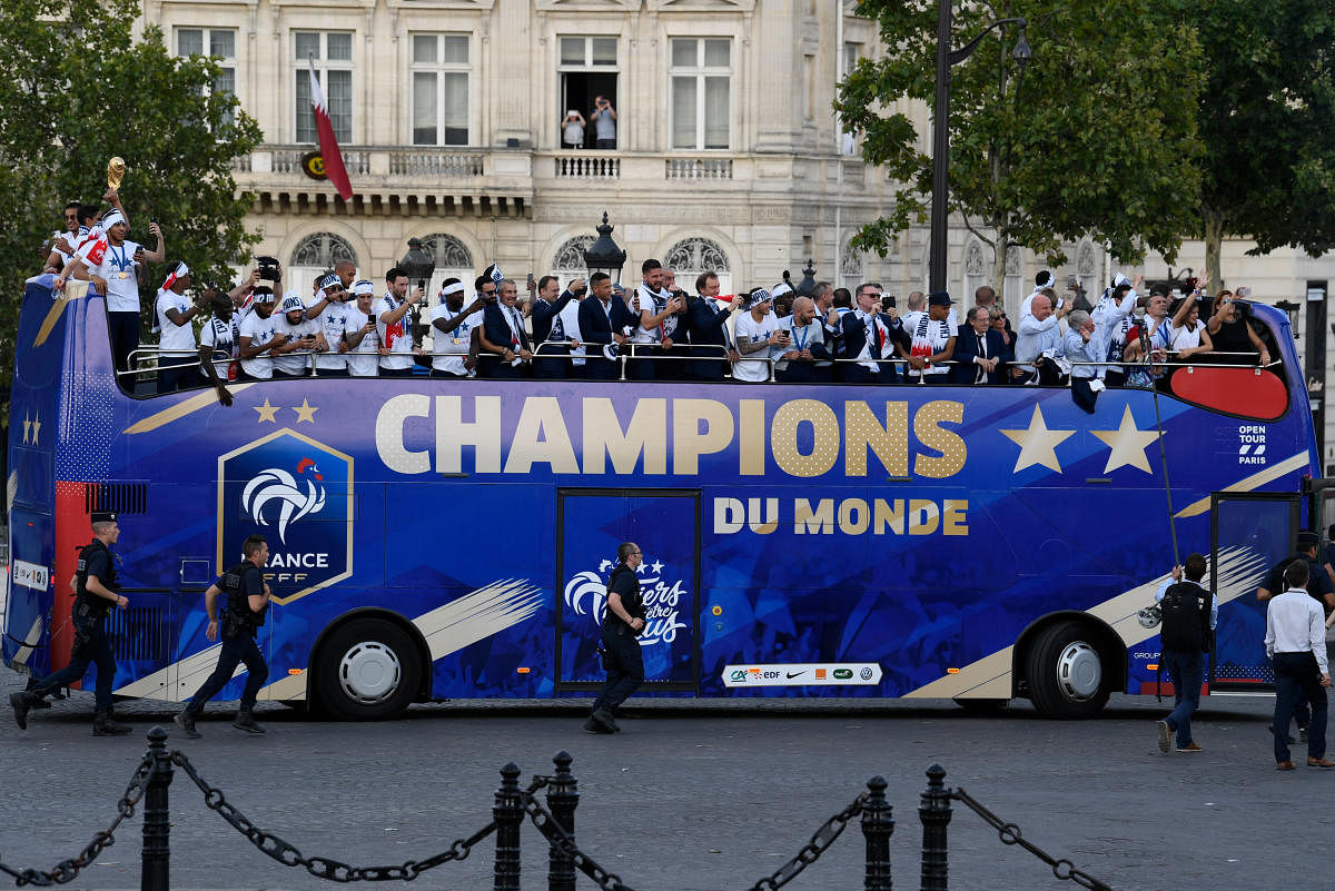 France's national soccer team players take pictures with their mobile phones as they celebrate with teammates and the trophy on the roof of a bus while parading down the Champs-Elysee avenue after winning the Russia 2018 World Cup final football match, in Paris, France July 16, 2018. (Eric Feferberg/Pool via Reuters)
