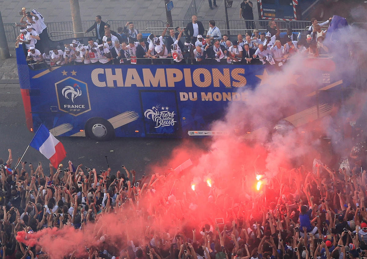 Fans let off a smoke cannister while the France team bus goes past during the parade. (REUTERS/Gonzalo Fuentes)