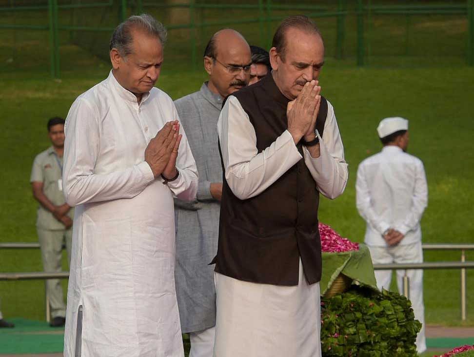 Senior Congress leaders Ghulam Nabi Azad and Ashok Gehlot pay tribute to India's first prime minister Pandit Jawaharlal Nehru on his 54th death anniversary, at Shanti Van, in New Delhi on Sunday.  PTI Photo