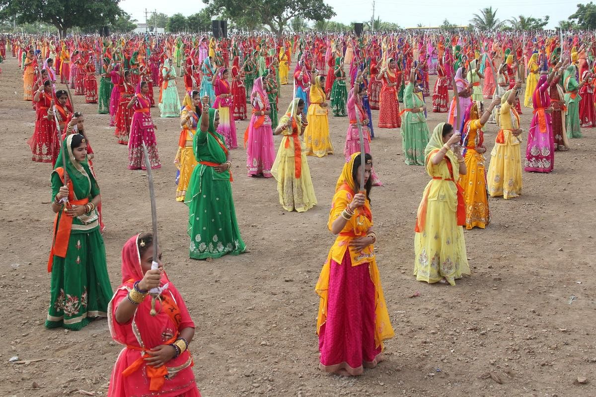 This handout photo taken on August 23, 2019 and released by the Gujarat Information Department, Jamnagar on August 24, 2019, shows Indian women of the Rajput community performing