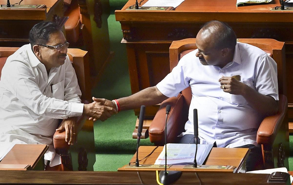 Karnataka Chief Minister H D Kumaraswamy and his deputy G Parameshwara greet each other after thier coalition government won the trust vote by voice vote, at Vidhana Soudha in Bengaluru, on Friday. PTI Photo