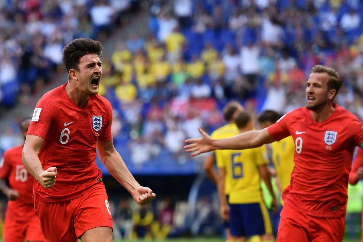 England's defender Harry Maguire (L) celebrates with England's forward Harry Kane after scoring the opener during the Russia 2018 World Cup quarter-final football match between Sweden and England at the Samara Arena in Samara. AFP Photo