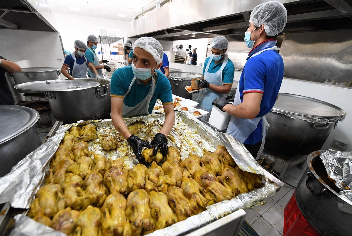 Volunteers prepare Iftar meals to be given to migrant workers during the Muslim holy month of Ramadan within the initiative of Sheikh Mohammed bin Rashid al-Maktoum, the ruler of Dubai, to distribute 10 million meals in Dubai. (AFP Photo)