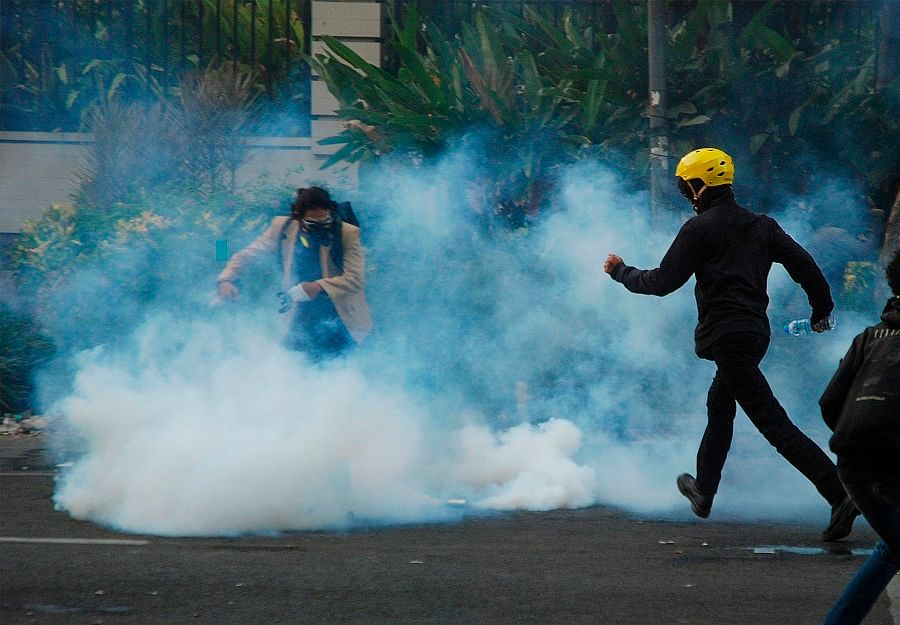 Indonesian protesters walk through teargas during a demonstration in Bandung. (AFP)