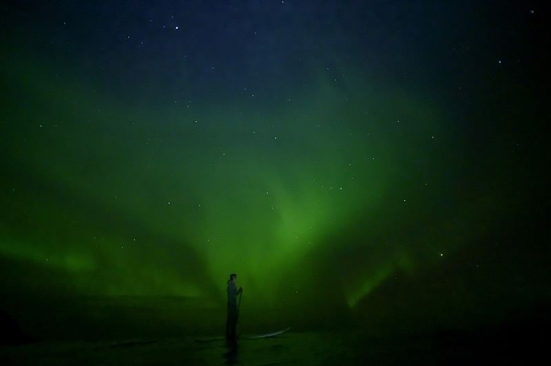 Indonesian surfer Edi Siswanto , rides a Stand-Up Paddle Board (SUP) under northern lights in Unstad, Lofoten Islands, beyond Arctic Circle. (AFP)