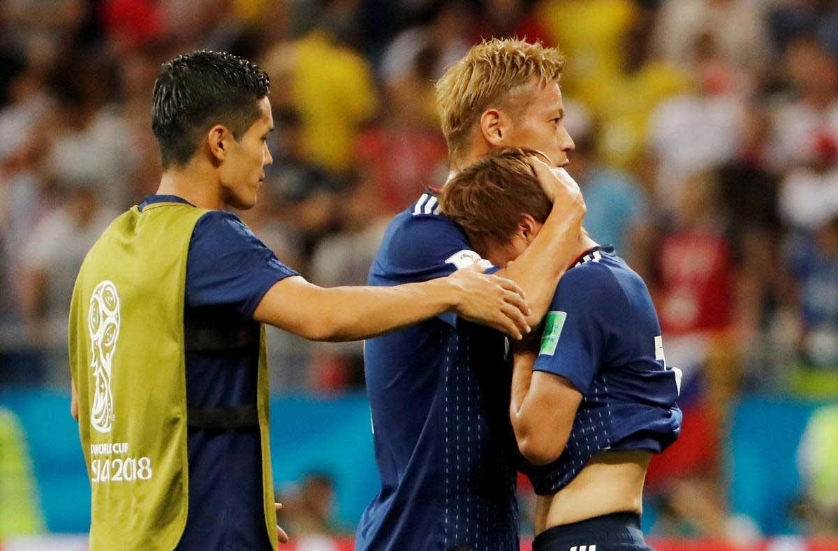 Japan's Takashi Inui is consoled by teammate Keisuke Honda after the match. REUTERS Photo
