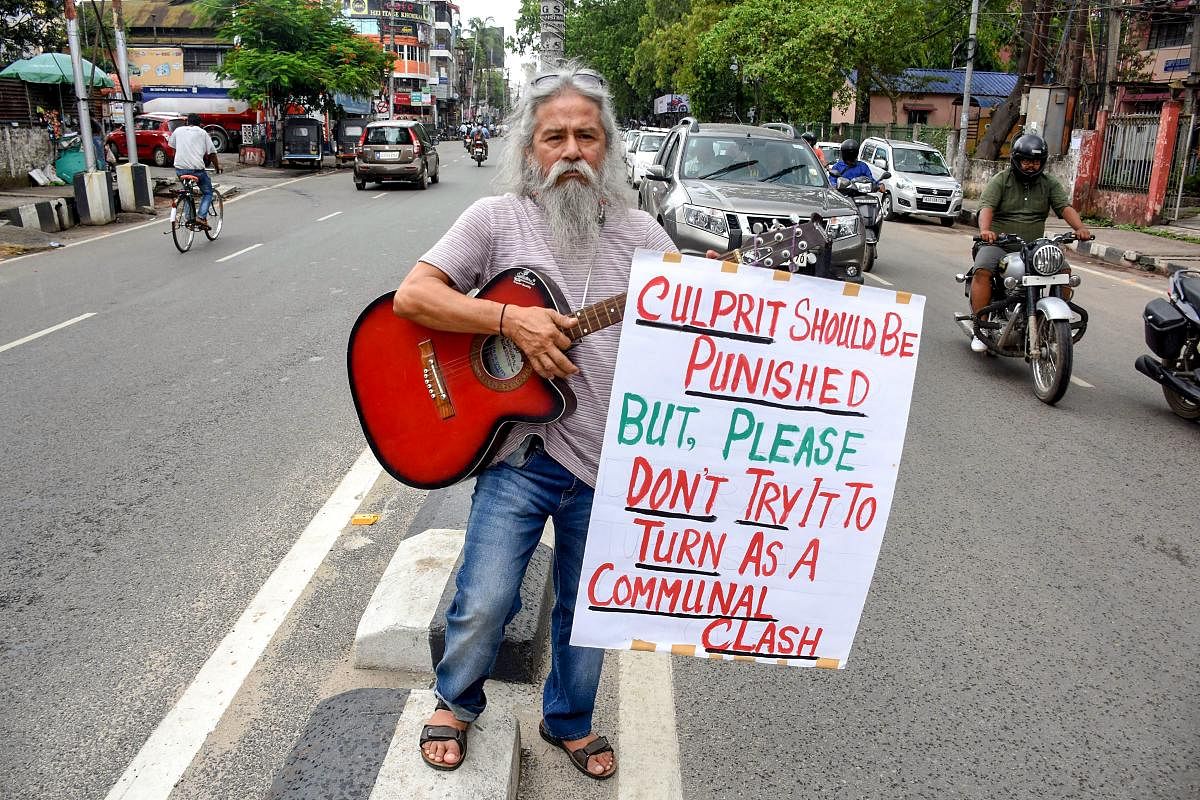 Singer and musician Kishore Giri stages a unique protest by playing the guitar demanding justice for Abhijeet Nath and Nilotpal Das who were allegedly beaten to death by a mob in Karbi Anglong district, in Guwahati on Tuesday. PTI Photo