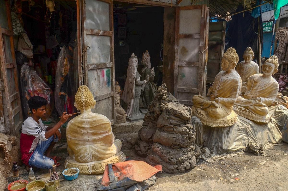 An artists create a sculpture of Lord Buddha at Kumortuli, in Kolkata on Sunday. PTI photo