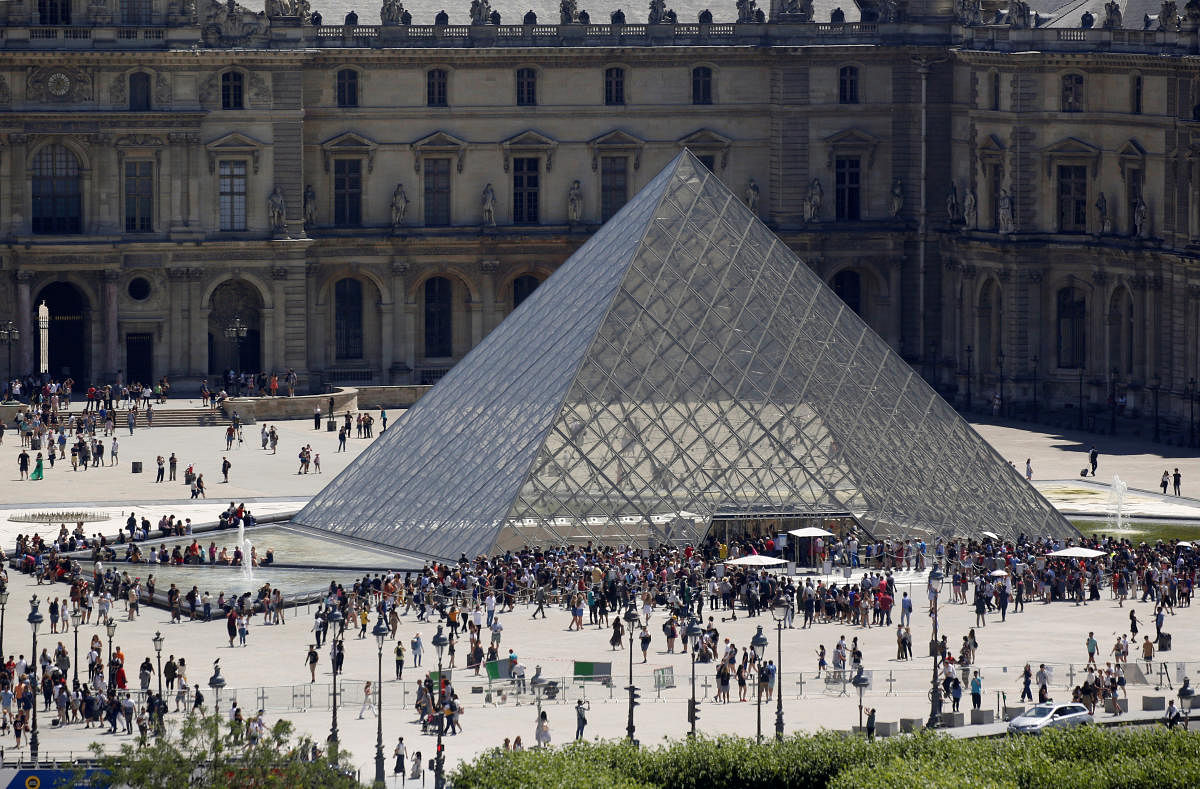A view shows tourists walking past the Louvre Pyramid designed by Chinese-born U.S. architect Ieoh Ming Pei outside the Louvre Museum in Paris, France. (Reuters Photo)
