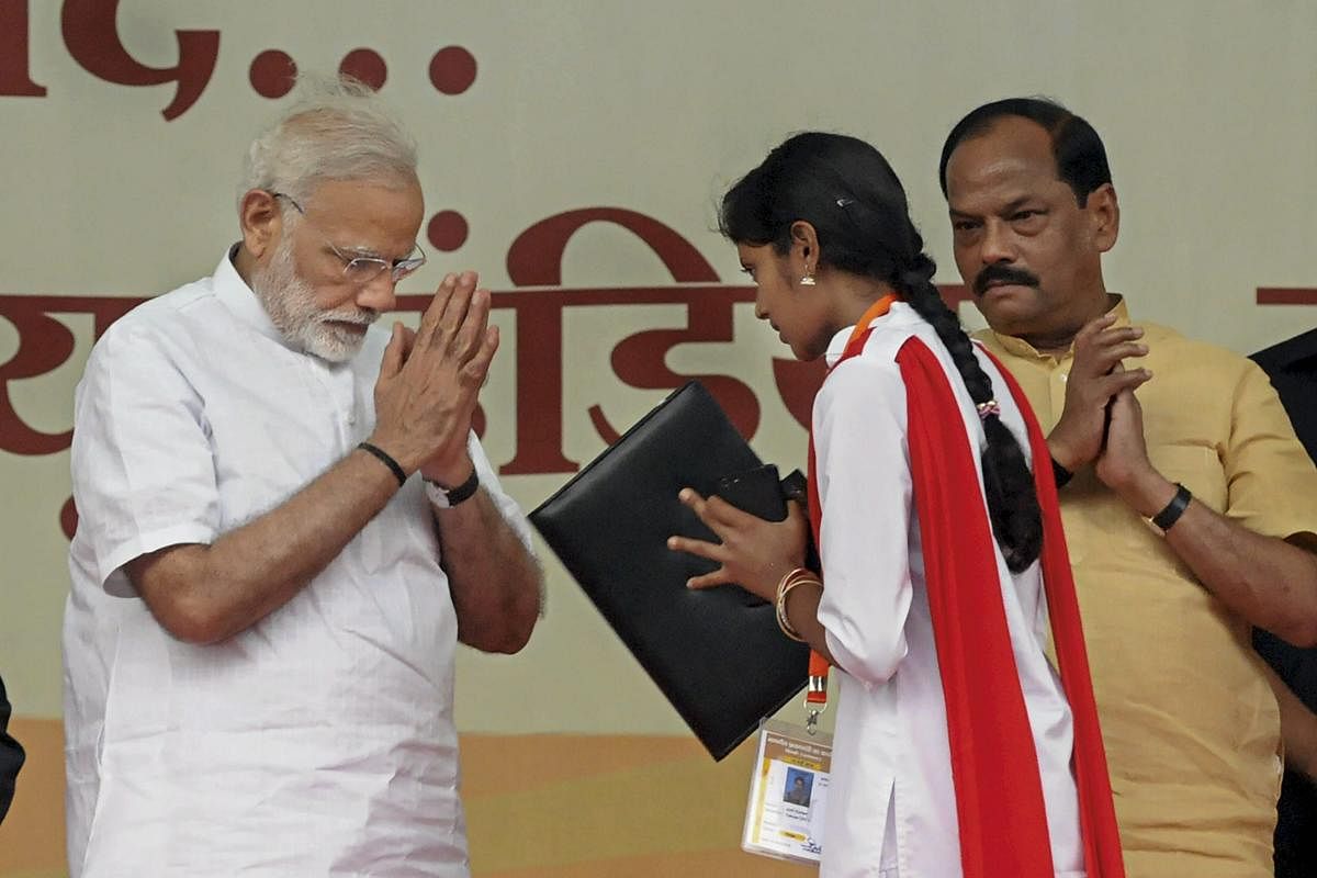 Prime Minister Narendra Modi presents appointment letters to the new recruits, as Jharkhand Chief Minister Raghubar Das looks on during the foundation stone laying ceremony of several projects, at Baliapur block of Dhanbad district, in Jharkhand, on Friday. PTI Photo