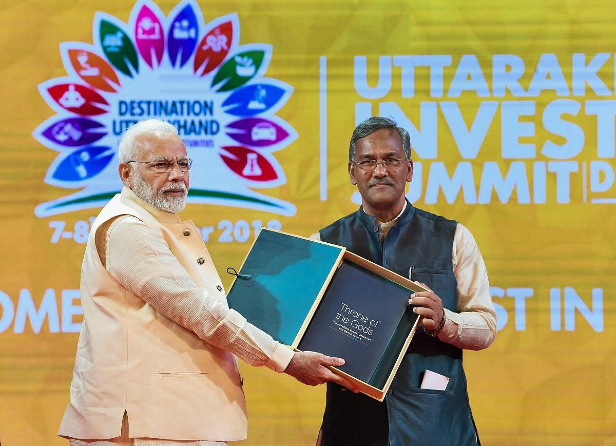 Prime Minister Narendra Modi being presented a memento by Chief Minister Trivendra Singh Rawat at the 1st Uttarakhand Investors Summit 2018, in Dehradun, Uttarakhand on Sunday. (PTI Photo)